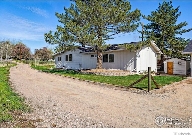 bungalow-style home featuring a storage shed, an outdoor structure, and board and batten siding