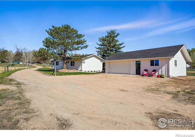 single story home featuring an outdoor structure and driveway