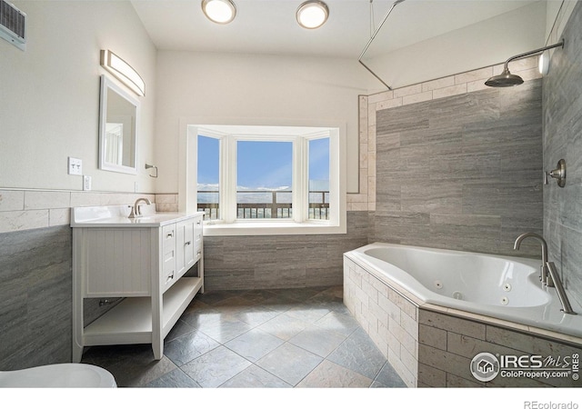 bathroom with visible vents, tile walls, a wainscoted wall, vanity, and tile patterned floors