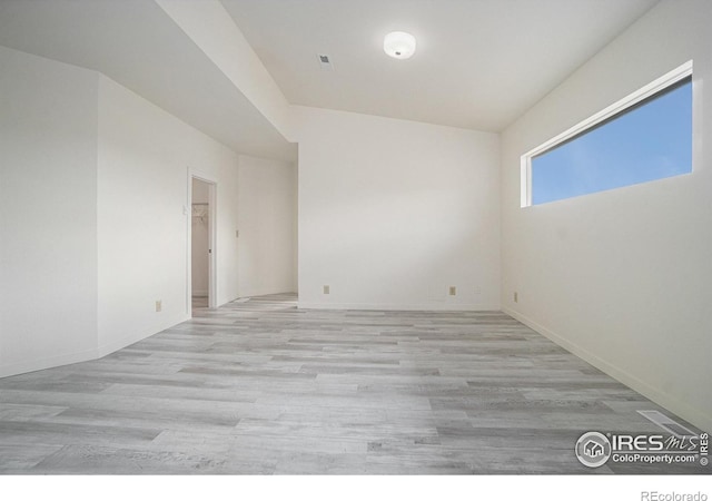 empty room featuring baseboards, visible vents, and light wood-style floors