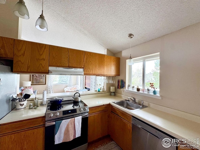 kitchen with extractor fan, a textured ceiling, brown cabinets, a sink, and appliances with stainless steel finishes