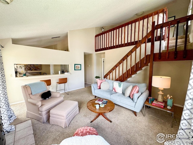 carpeted living area featuring stairs, a textured ceiling, baseboards, and lofted ceiling