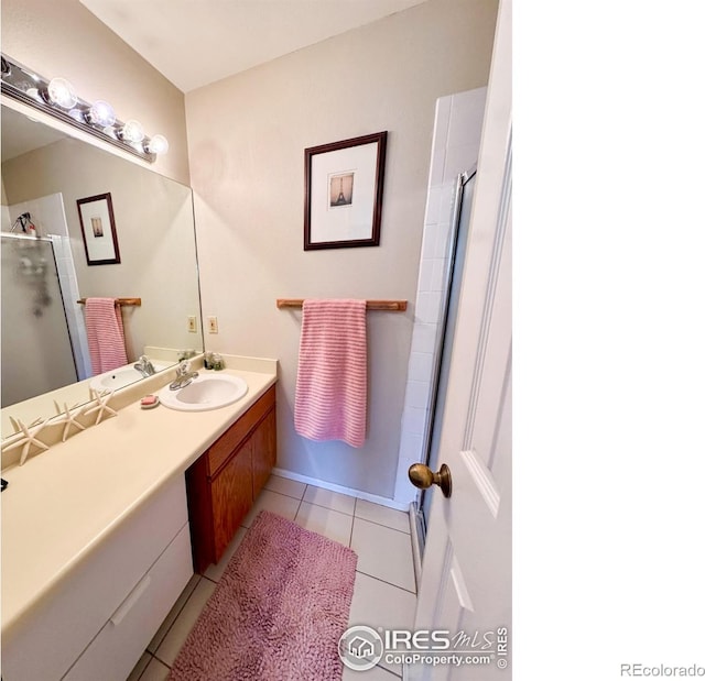 bathroom featuring vanity, tile patterned flooring, and a shower with shower door