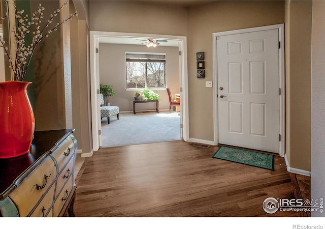 foyer entrance featuring baseboards, ceiling fan, and wood finished floors