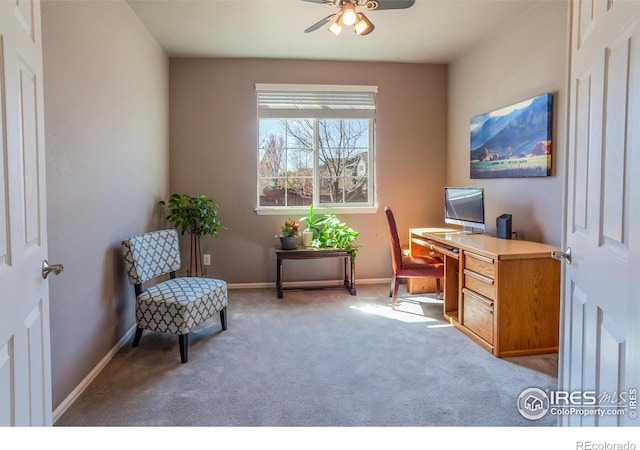 carpeted office space featuring baseboards and a ceiling fan