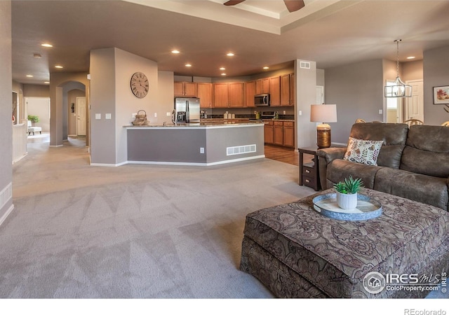 living area with recessed lighting, arched walkways, a ceiling fan, and light colored carpet