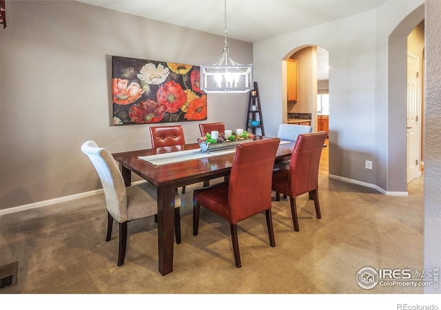 dining area with a notable chandelier, arched walkways, carpet, baseboards, and visible vents