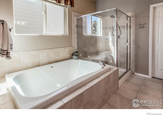 full bathroom with baseboards, tile patterned flooring, a stall shower, and a bath