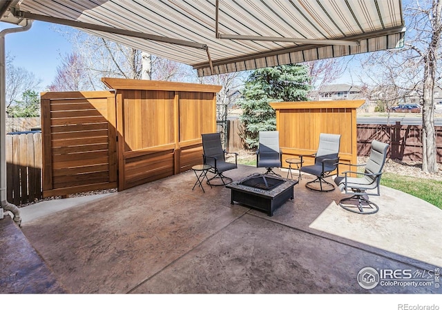 view of patio with a fire pit, a fenced backyard, and a storage unit