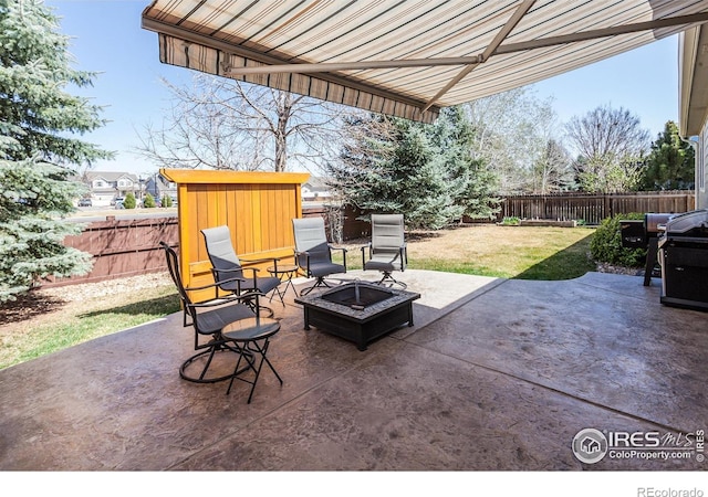 view of patio / terrace featuring an outdoor structure, a fenced backyard, an outdoor fire pit, and a shed