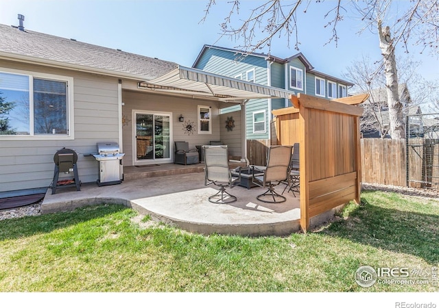back of property with a yard, a patio, and fence