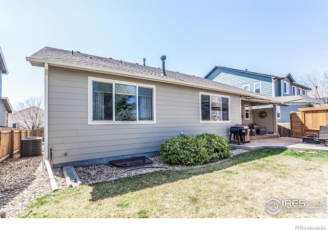 back of property featuring a fenced backyard, a yard, a patio area, and central AC