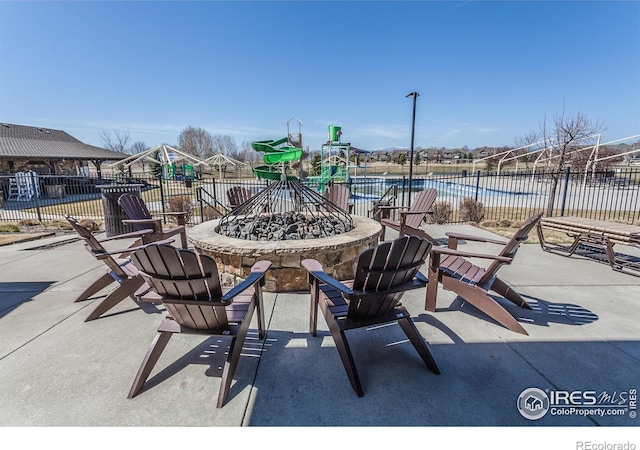 view of patio featuring fence and a fire pit