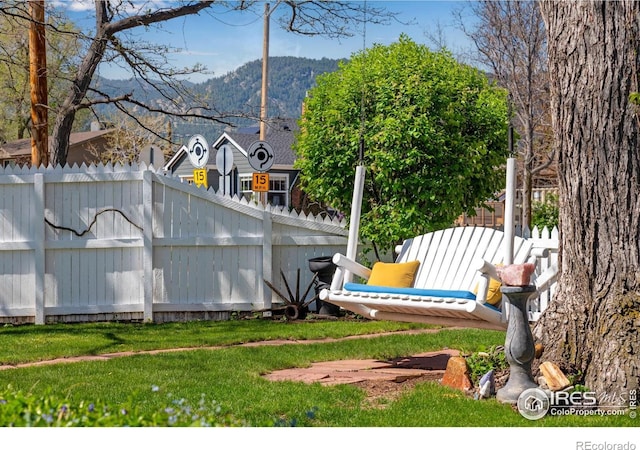 view of yard featuring a mountain view and fence