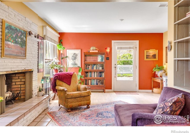 sitting room with baseboards and a tile fireplace