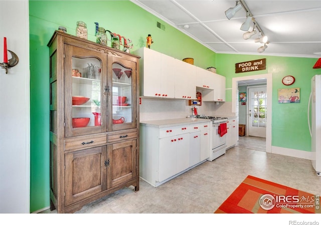 kitchen with white appliances, light countertops, rail lighting, and white cabinets