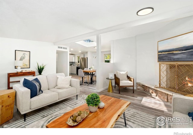 living area featuring recessed lighting, baseboards, visible vents, and wood finished floors