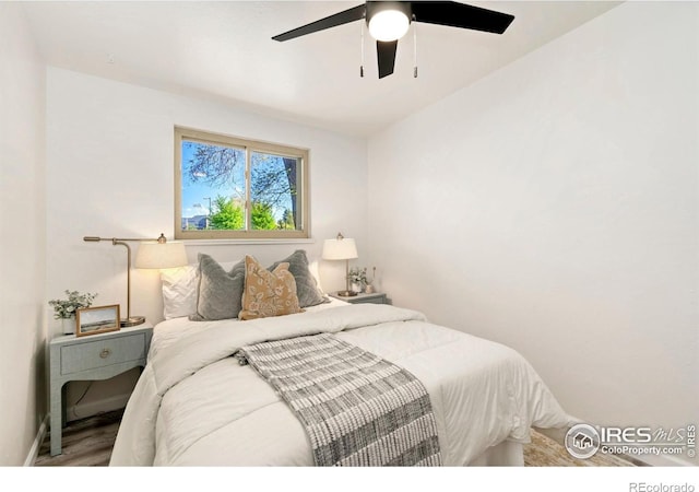 bedroom featuring a ceiling fan, baseboards, and wood finished floors