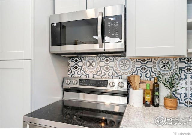 kitchen with light countertops, white cabinetry, appliances with stainless steel finishes, and tasteful backsplash