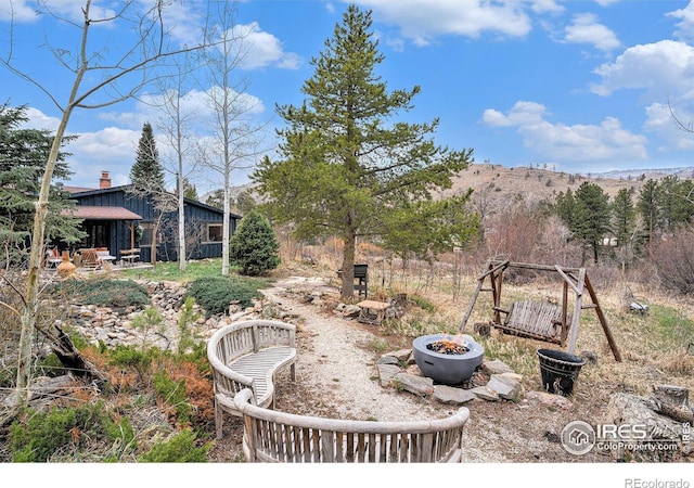 view of yard featuring an outdoor fire pit, a mountain view, and a patio area