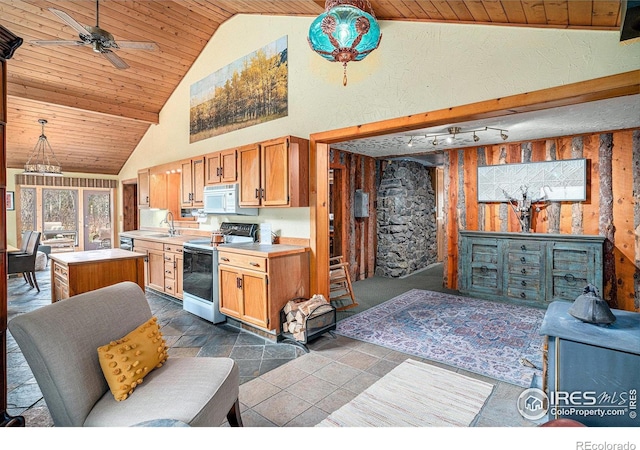 kitchen featuring range with electric cooktop, white microwave, light countertops, a center island, and a sink