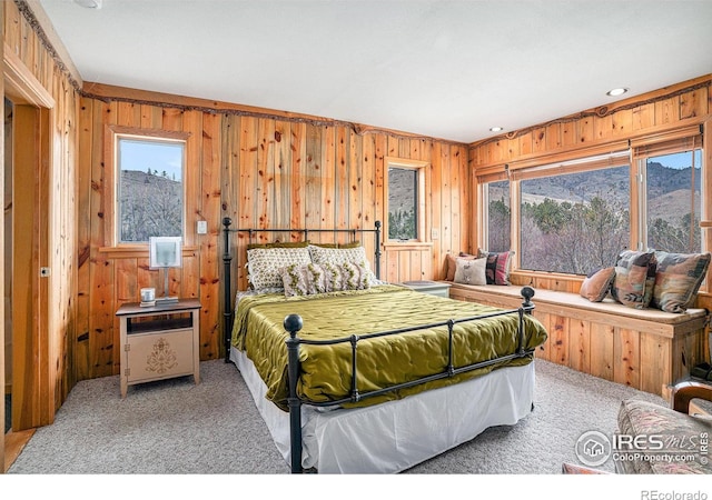 bedroom featuring wooden walls, carpet, multiple windows, and recessed lighting