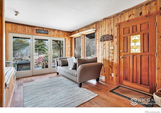 living area with wooden walls and light wood finished floors
