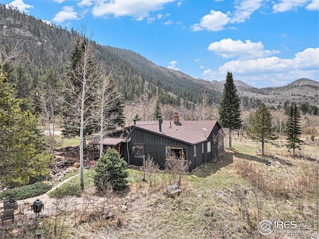 view of mountain backdrop with a heavily wooded area