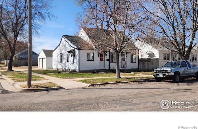 401 Park St, Sterling, CO 80751 - bungalow-style house with a detached garage, fence, and a front lawn