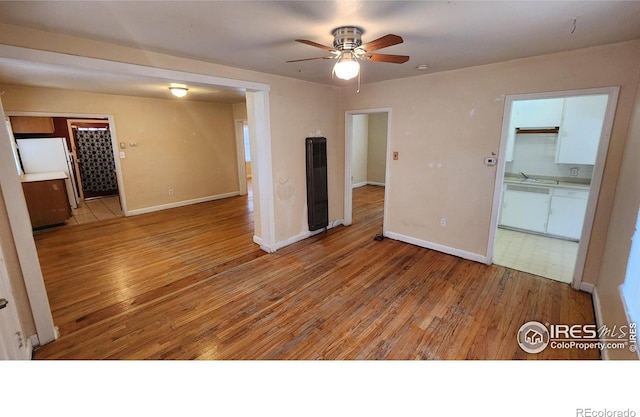 401 Park St, Sterling, CO 80751 - spare room featuring a heating unit, ceiling fan, baseboards, and hardwood / wood-style floors