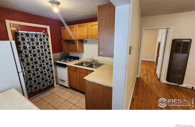 401 Park St, Sterling, CO 80751 - kitchen with a sink, white appliances, light countertops, a heating unit, and backsplash