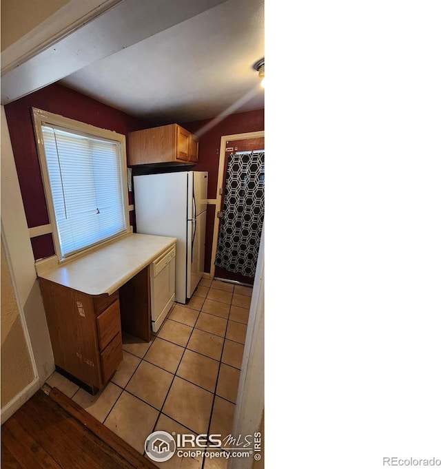 401 Park St, Sterling, CO 80751 - kitchen featuring freestanding refrigerator, light tile patterned floors, and light countertops