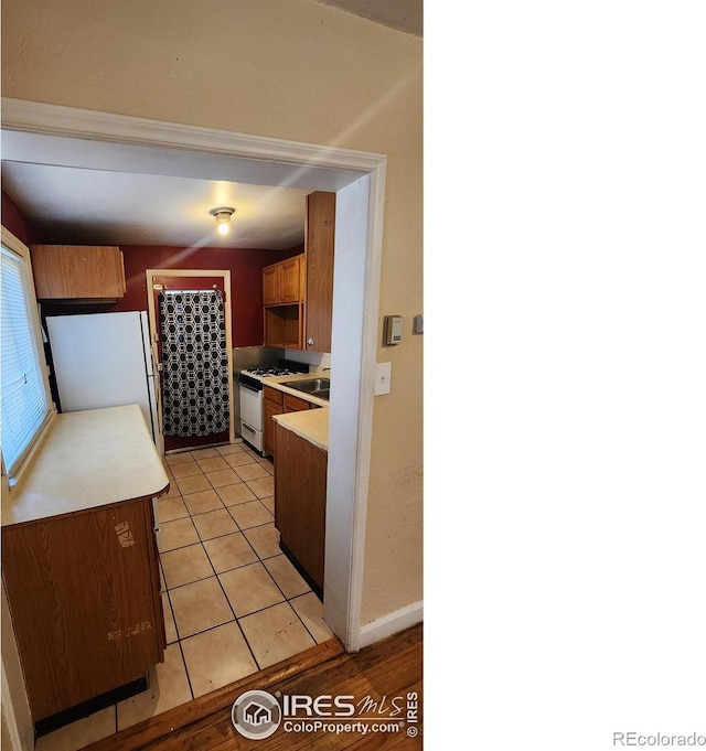 401 Park St, Sterling, CO 80751 - kitchen with white appliances, light tile patterned floors, and light countertops