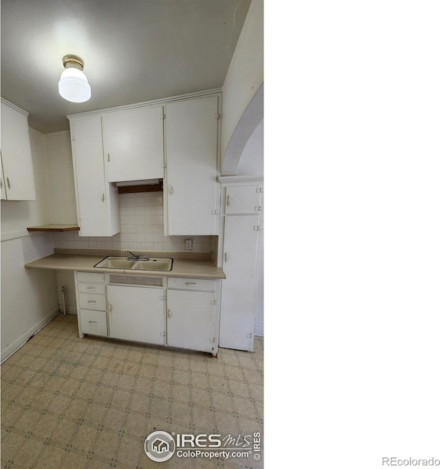 401 Park St, Sterling, CO 80751 - kitchen with a sink, light floors, and white cabinetry
