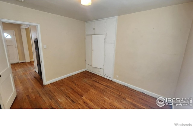 401 Park St, Sterling, CO 80751 - unfurnished room with baseboards and wood finished floors