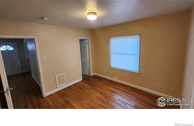 401 Park St, Sterling, CO 80751 - unfurnished room with baseboards, wood finished floors, and visible vents