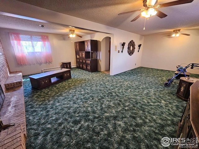 living area with ceiling fan, arched walkways, a textured ceiling, carpet, and a baseboard heating unit