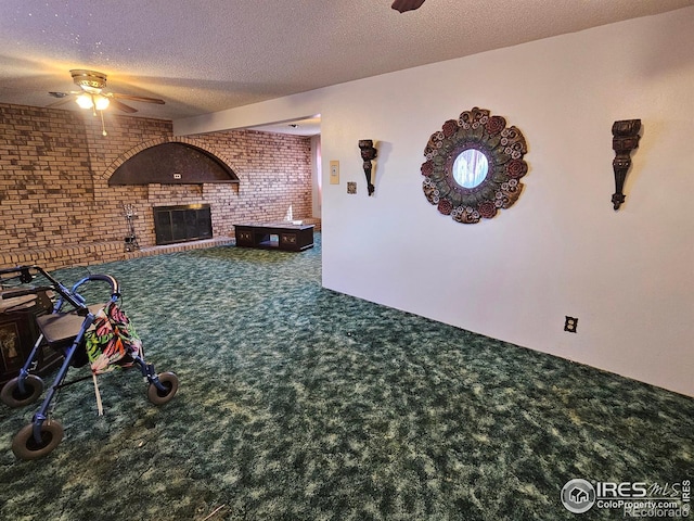 living room with carpet flooring, a ceiling fan, a textured ceiling, and a brick fireplace