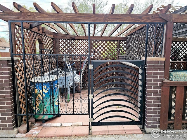 view of gate featuring fence and a pergola