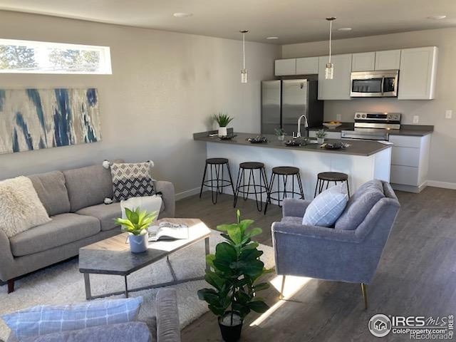 living room featuring recessed lighting, baseboards, and wood finished floors