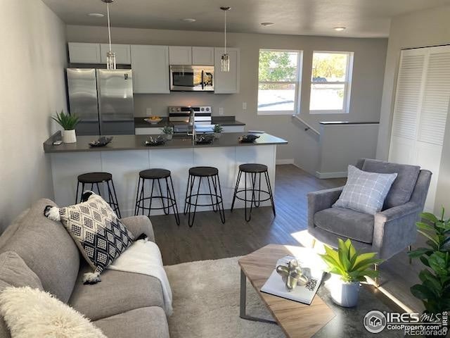 living area featuring recessed lighting, baseboards, and wood finished floors