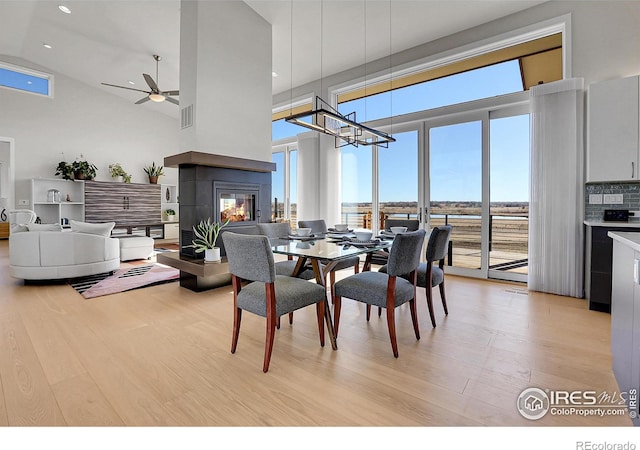 11251 Lookout Dr, Longmont, CO 80504 - dining space featuring light wood finished floors, a towering ceiling, plenty of natural light, ceiling fan, and a chandelier
