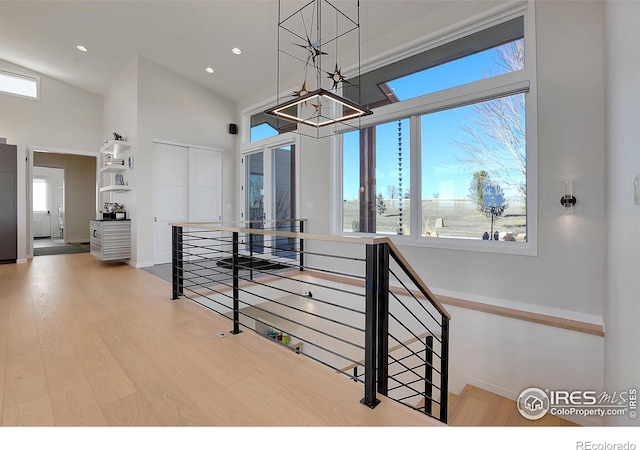11251 Lookout Dr, Longmont, CO 80504 - staircase with a chandelier, a high ceiling, wood finished floors, recessed lighting, and baseboards