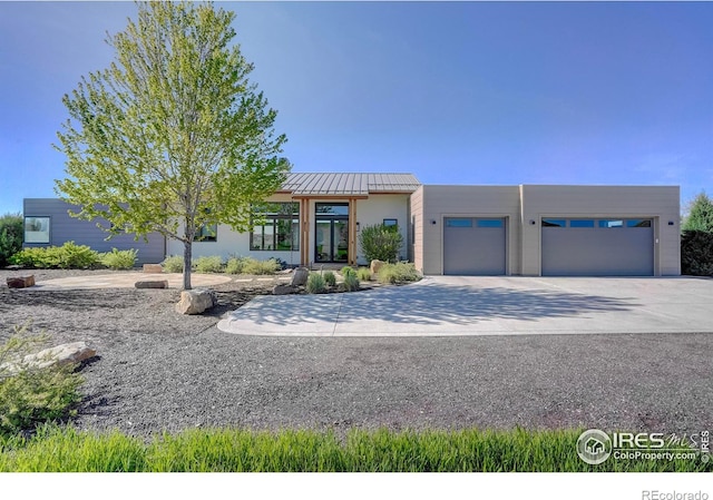 11251 Lookout Dr, Longmont, CO 80504 - pueblo revival-style home featuring a garage, concrete driveway, a standing seam roof, and metal roof