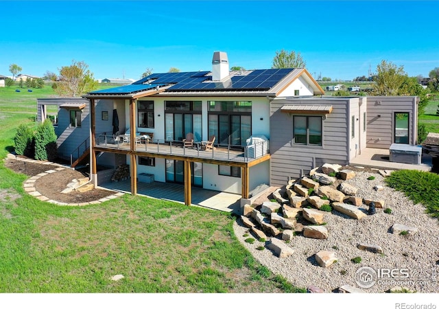11251 Lookout Dr, Longmont, CO 80504 - rear view of house featuring solar panels, a patio, a yard, and a chimney