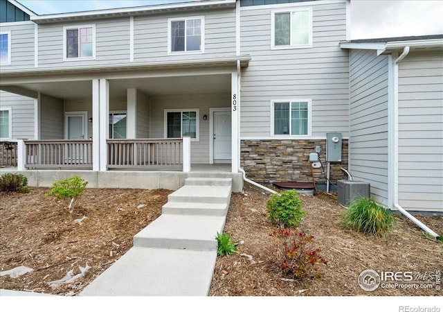 4355 24th Street Rd Unit 803, Greeley, CO 80634 - doorway to property featuring cooling unit, a porch, and stone siding