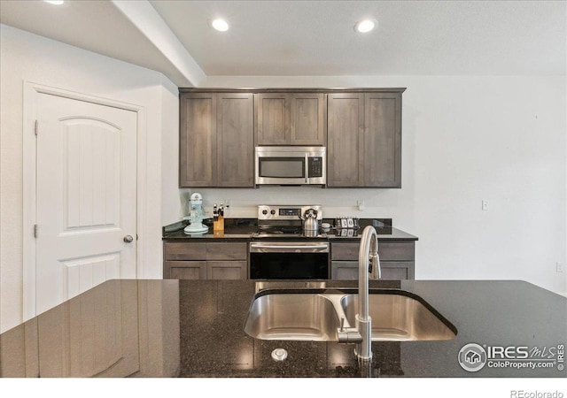 4355 24th Street Rd Unit 803, Greeley, CO 80634 - kitchen featuring dark brown cabinetry, a sink, dark stone countertops, stainless steel appliances, and recessed lighting