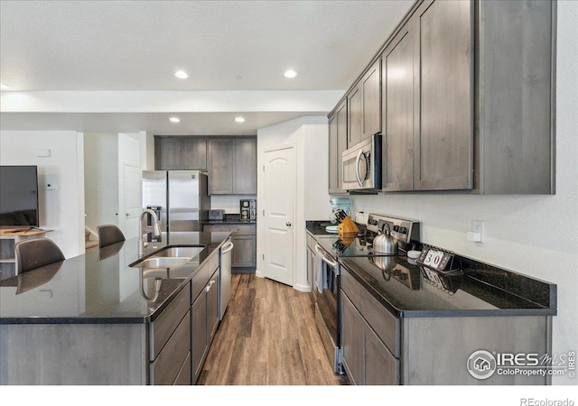 4355 24th Street Rd Unit 803, Greeley, CO 80634 - kitchen featuring wood finished floors, a sink, dark stone countertops, stainless steel appliances, and recessed lighting