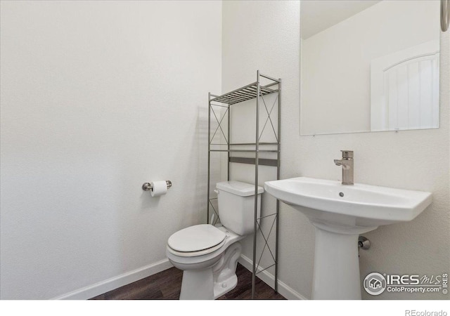 4355 24th Street Rd Unit 803, Greeley, CO 80634 - half bathroom featuring baseboards, a sink, wood finished floors, and toilet