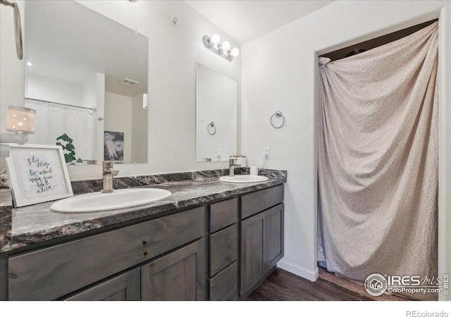 4355 24th Street Rd Unit 803, Greeley, CO 80634 - bathroom featuring a sink, double vanity, wood finished floors, and visible vents